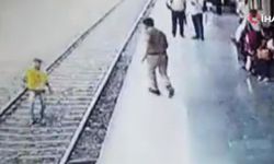 Hindistan'da polis raylara atlayan genci son anda kurtardı